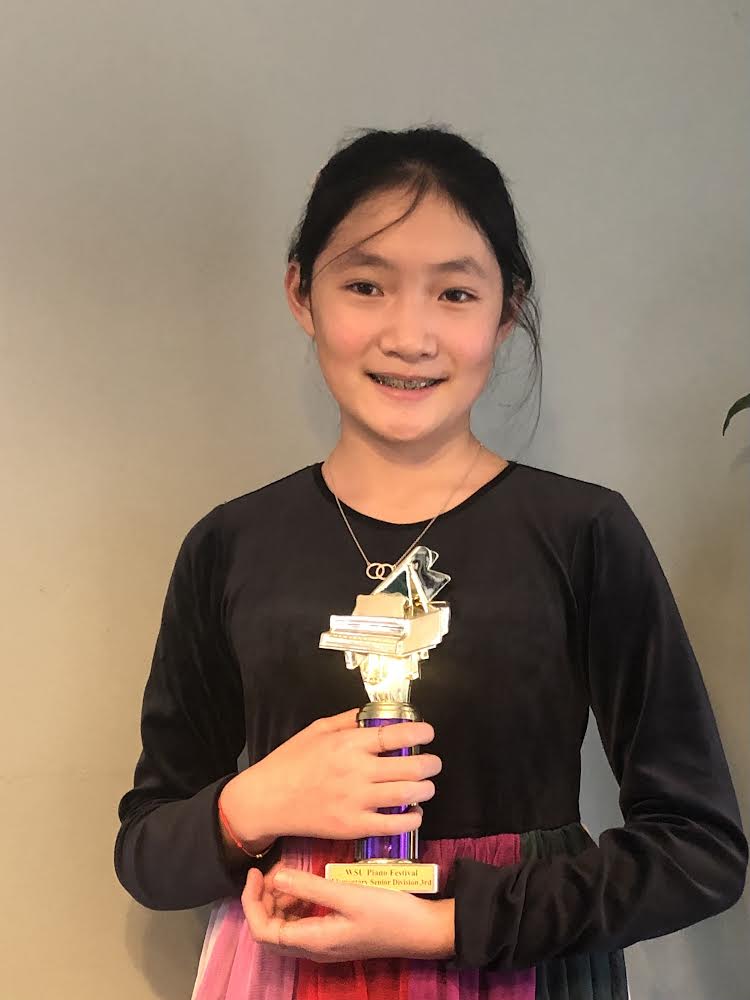 Pianist Kourtney Jia holds a trophy.