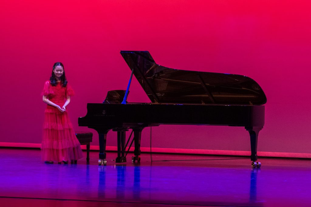 Christina Sung standing at the piano