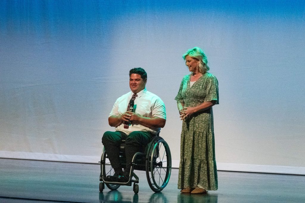 Max Togisala-Guest speaker on stage with his mother. Max uses a wheelchair. 