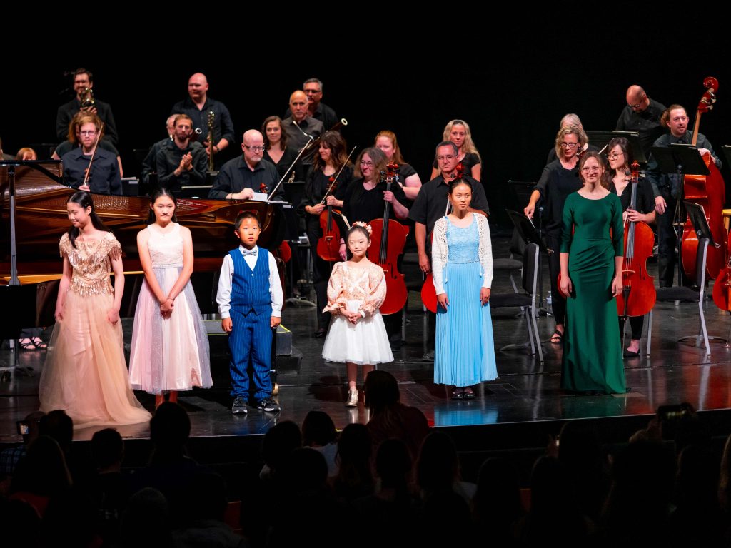 Prodigy Concert Performers standing in front of Orchestra at the Egyptian Theatre in Ogden, Utah